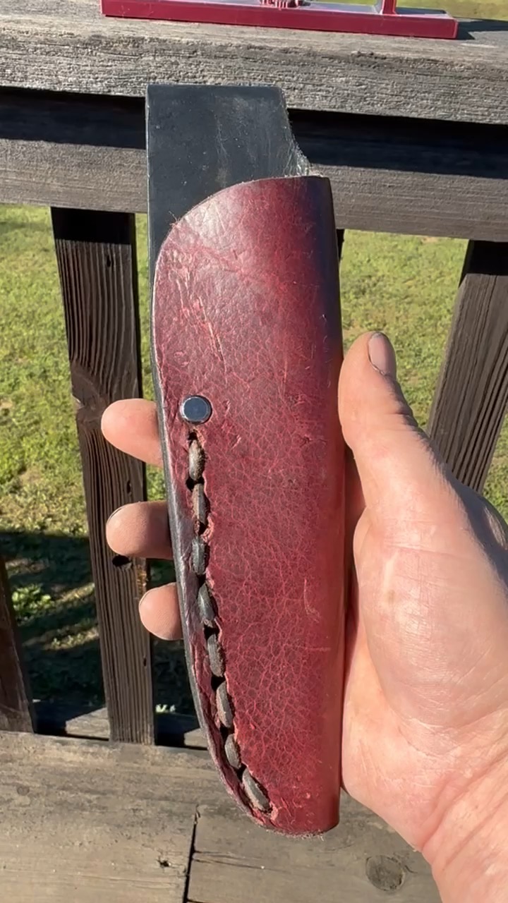 Burgundy hand-stitched leather sheath holding a compact knife