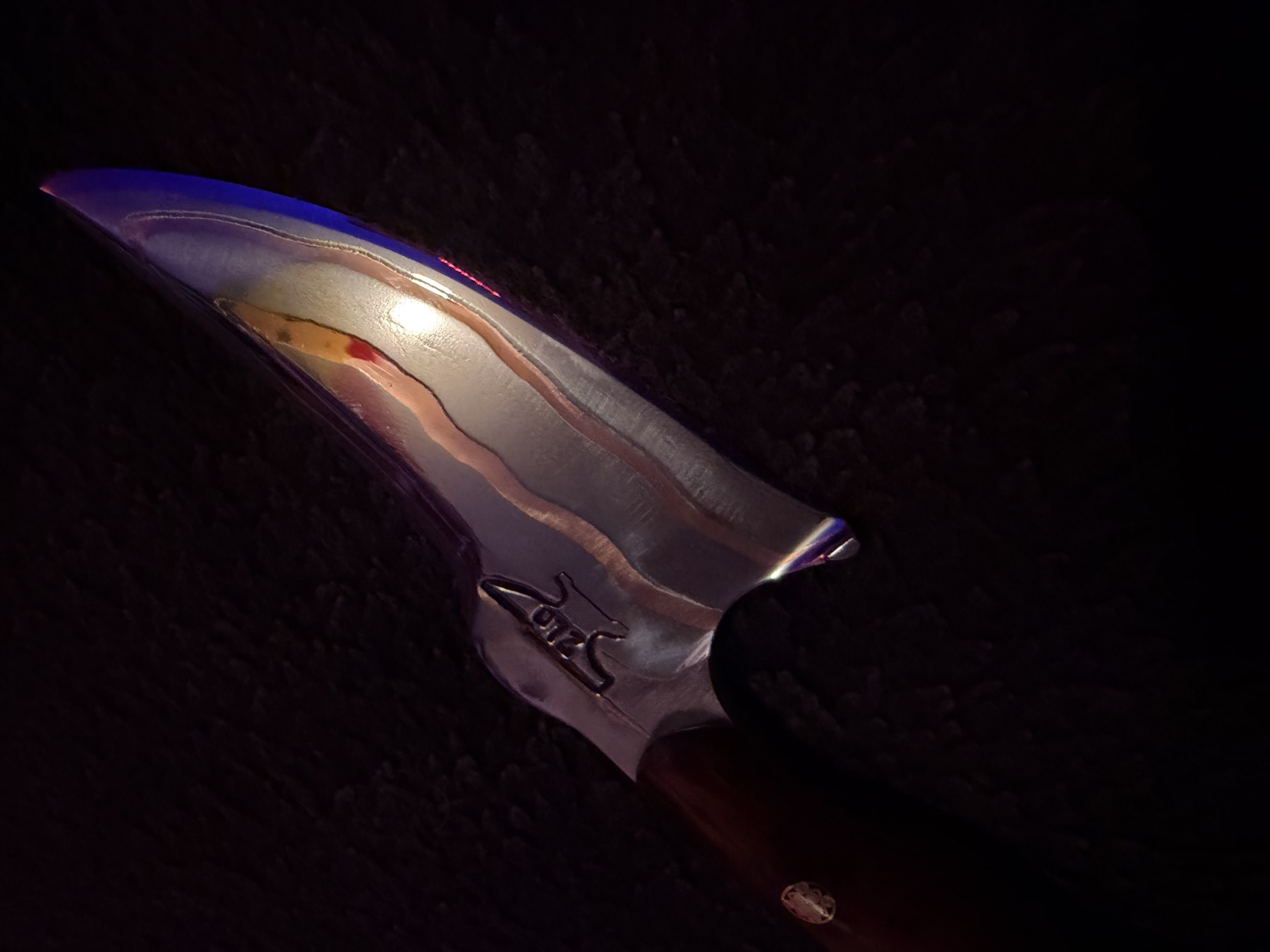 Close detail of the polished Tulos blade with flowing copper inlay lines
