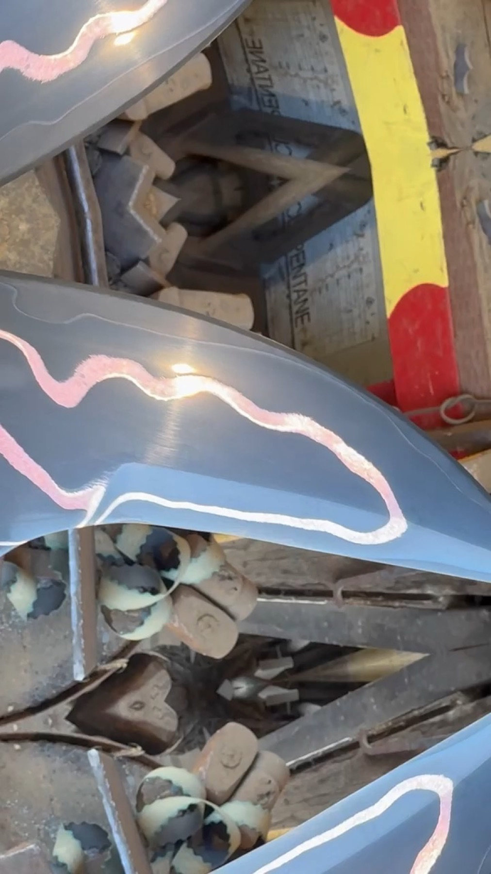 Copper inlay lines being polished on several unfinished Tulos blades at the workbench