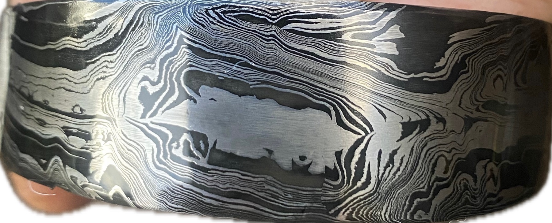 Extreme close-up of the layered pattern in a polished Damascus steel blade
