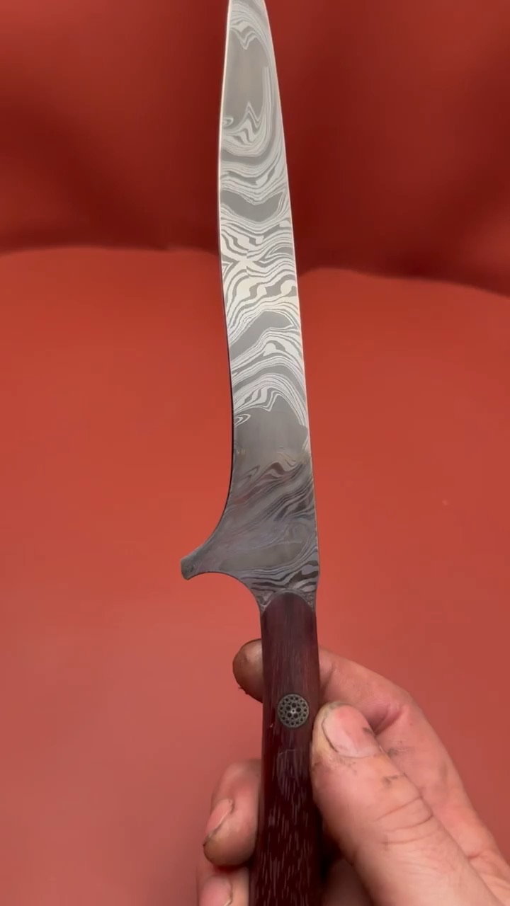 Long slender Damascus knife with a dark red wood handle