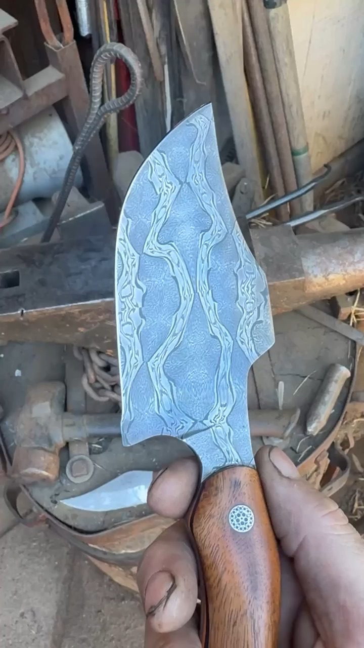Freshly finished pattern-welded blade held in the workshop